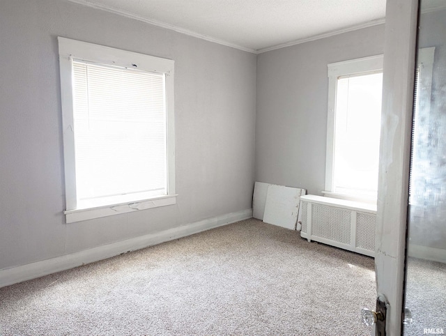 carpeted spare room with radiator and ornamental molding