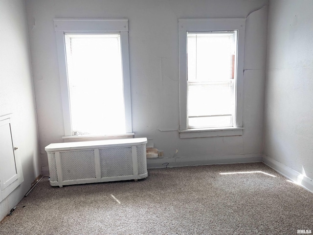 unfurnished room with carpet and radiator heating unit