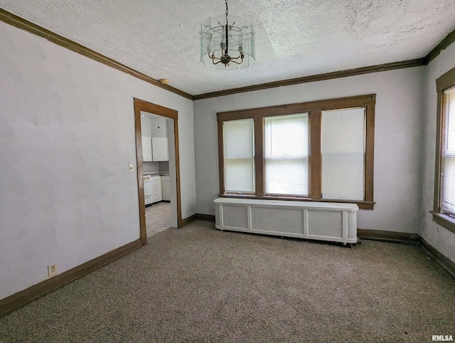 carpeted spare room with a notable chandelier, ornamental molding, a textured ceiling, and radiator heating unit