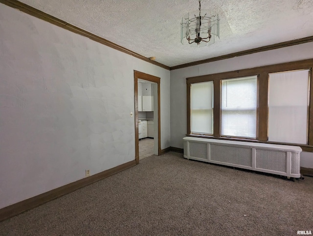 carpeted spare room with a textured ceiling, radiator, crown molding, and a notable chandelier