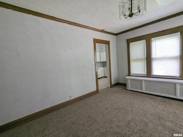 empty room featuring a textured ceiling, crown molding, carpet floors, and radiator heating unit