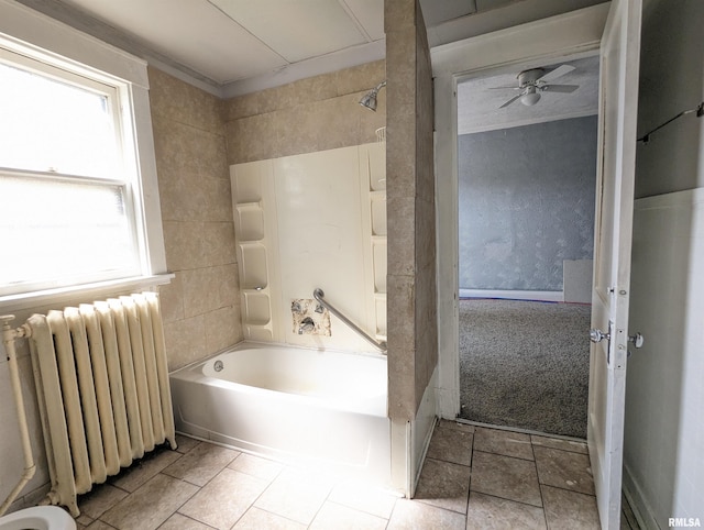 bathroom with ceiling fan, bathtub / shower combination, and radiator heating unit