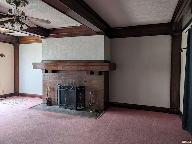 unfurnished living room with ceiling fan, a fireplace, beam ceiling, carpet flooring, and a textured ceiling