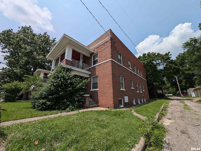 view of home's exterior featuring a yard and a balcony