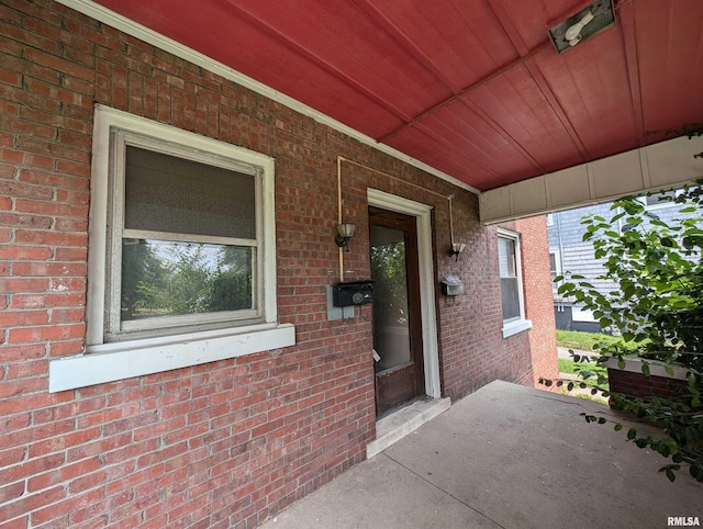 view of exterior entry featuring covered porch