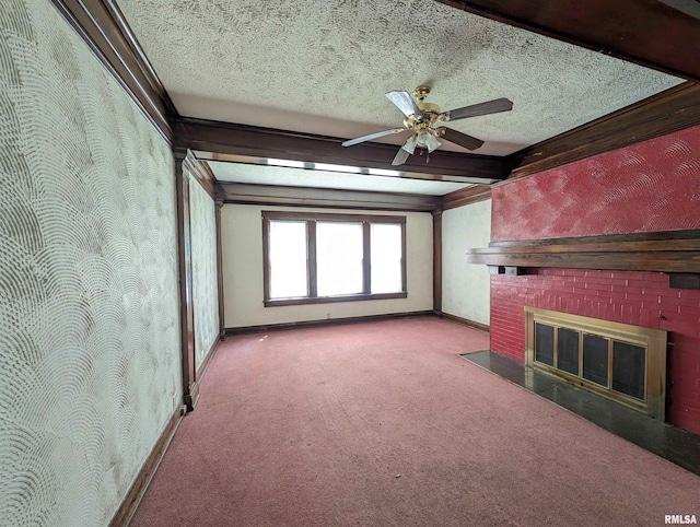 unfurnished living room featuring a textured ceiling, carpet floors, beamed ceiling, ceiling fan, and a brick fireplace