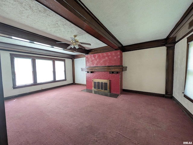 unfurnished living room with a brick fireplace, ceiling fan, a textured ceiling, carpet flooring, and beamed ceiling