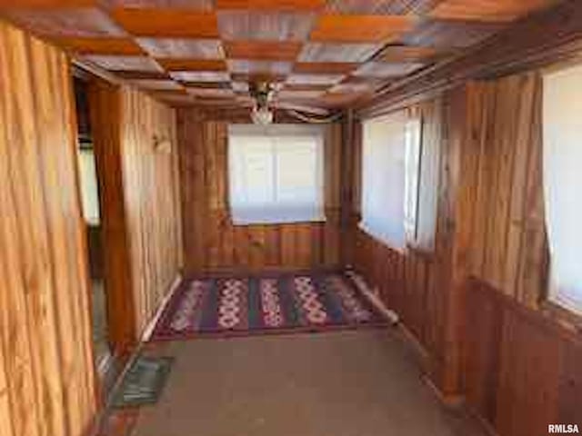 misc room featuring coffered ceiling and wood walls