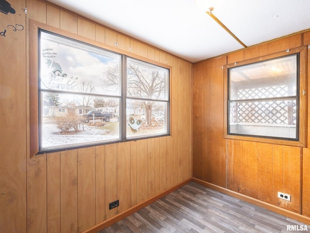 empty room with wood-type flooring and wood walls