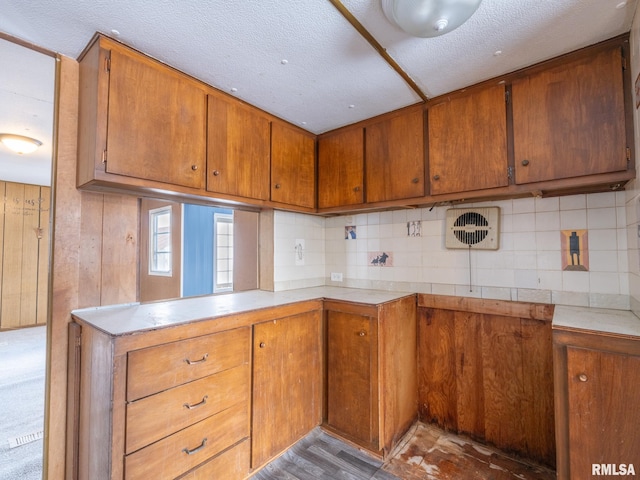 kitchen with a textured ceiling, light hardwood / wood-style flooring, and backsplash