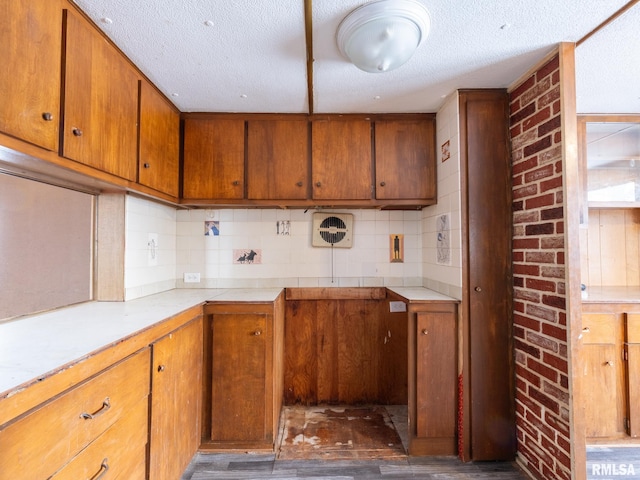 kitchen with a textured ceiling, dark wood-type flooring, and tasteful backsplash