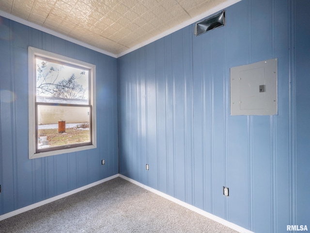 empty room with crown molding, electric panel, a healthy amount of sunlight, and carpet