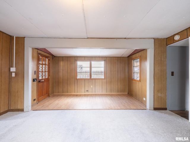 empty room with light carpet and wood walls