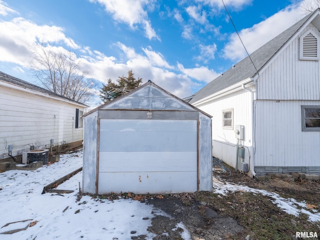 snow covered garage with central AC unit