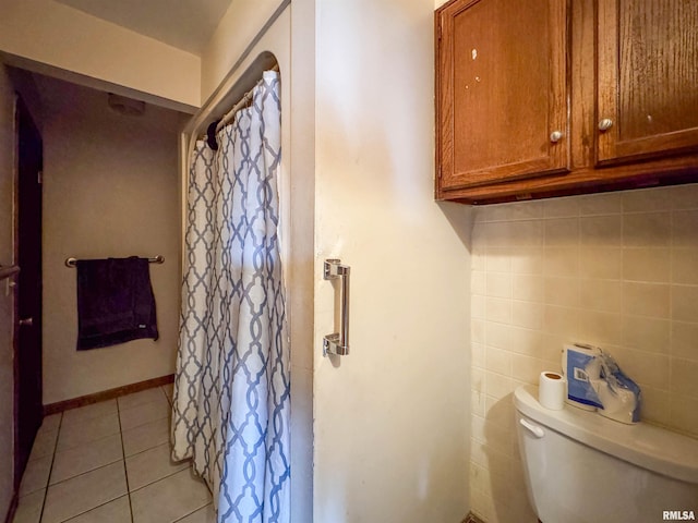 bathroom featuring tile walls, tile patterned floors, and toilet