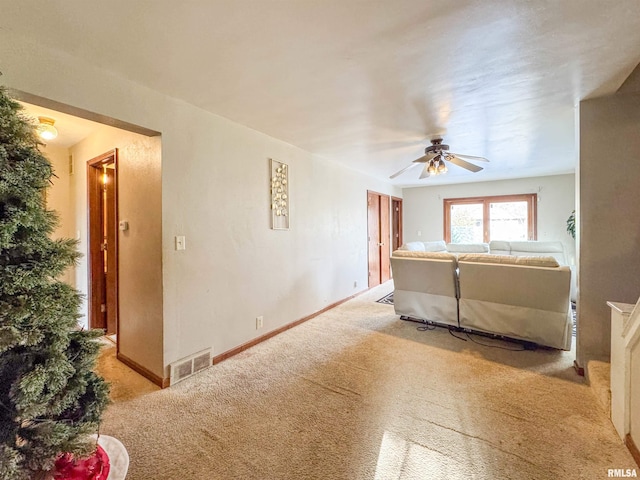 unfurnished living room featuring ceiling fan and light colored carpet