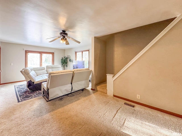 living room with ceiling fan and carpet