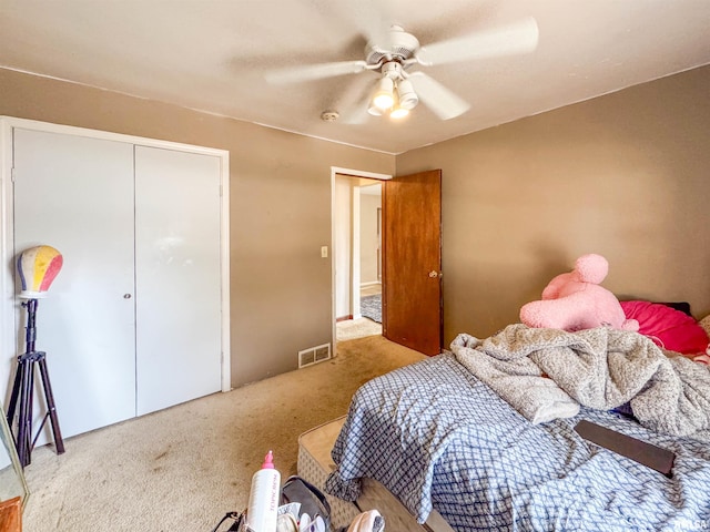 bedroom with ceiling fan, light colored carpet, and a closet