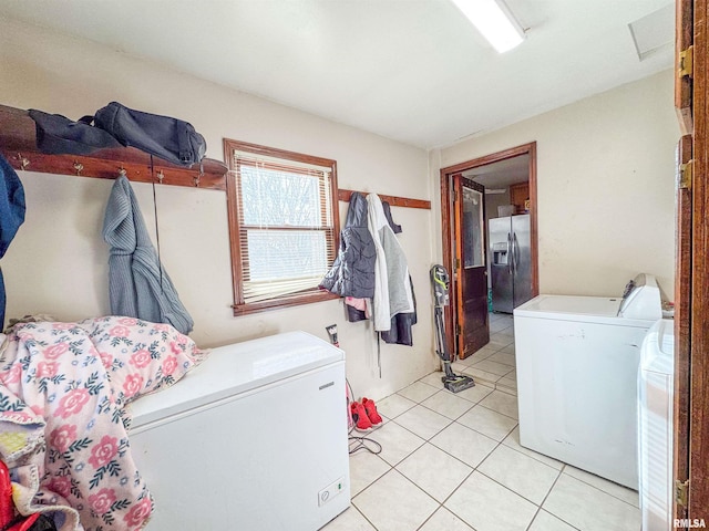 laundry area featuring washer and clothes dryer and light tile patterned floors