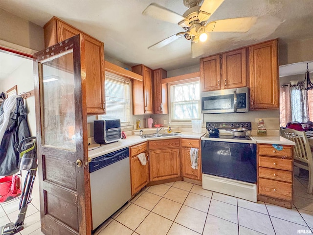 kitchen featuring light tile patterned floors, stainless steel appliances, ceiling fan, and sink