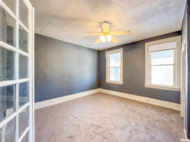 carpeted spare room with a textured ceiling and ceiling fan