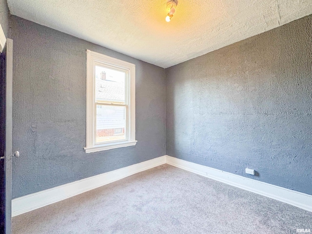 carpeted spare room with a textured ceiling