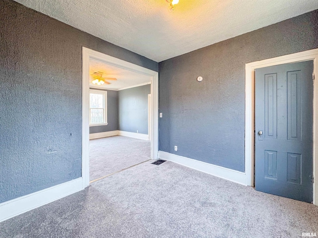 carpeted spare room with a textured ceiling