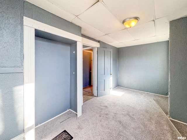 interior space with carpet and a drop ceiling