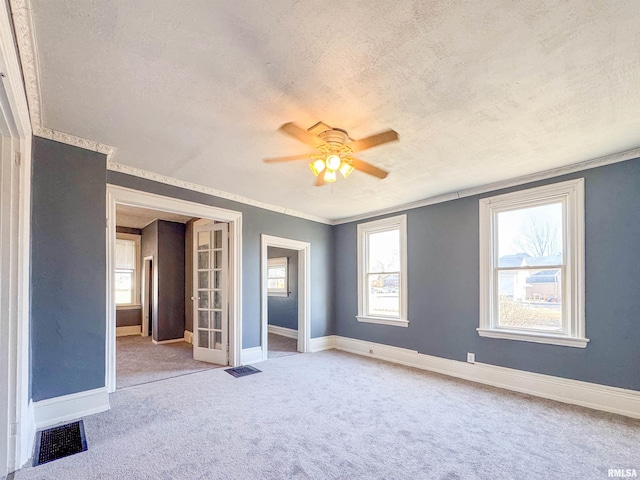 unfurnished bedroom featuring a textured ceiling, ceiling fan, carpet, and multiple windows