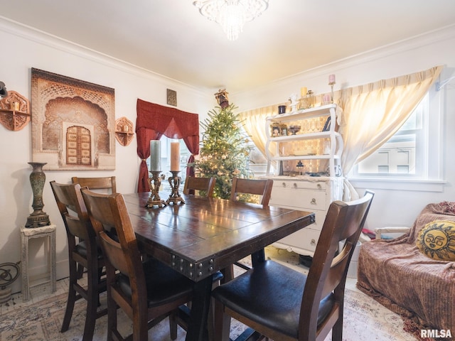 dining room featuring plenty of natural light, crown molding, and an inviting chandelier