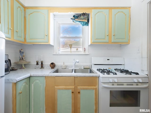 kitchen featuring sink, white range with gas cooktop, and tasteful backsplash