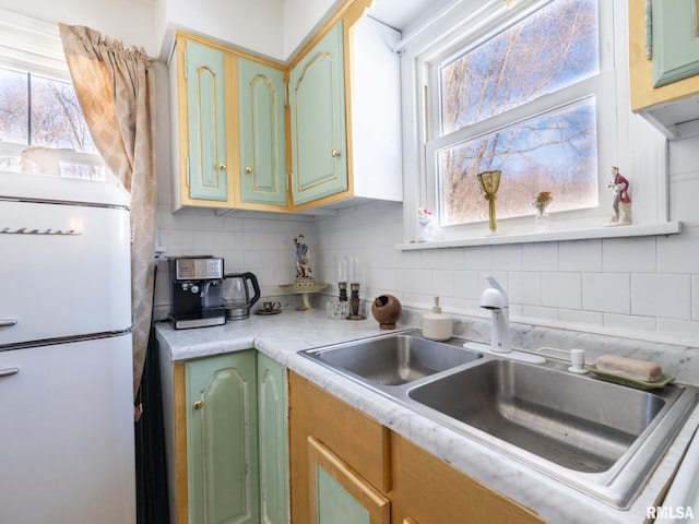 kitchen with backsplash, sink, and white fridge