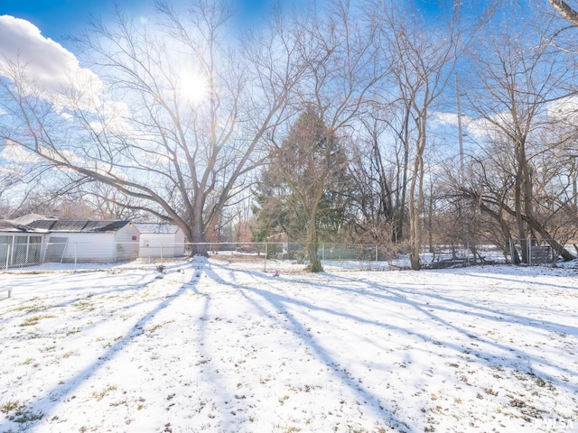 yard layered in snow with a shed