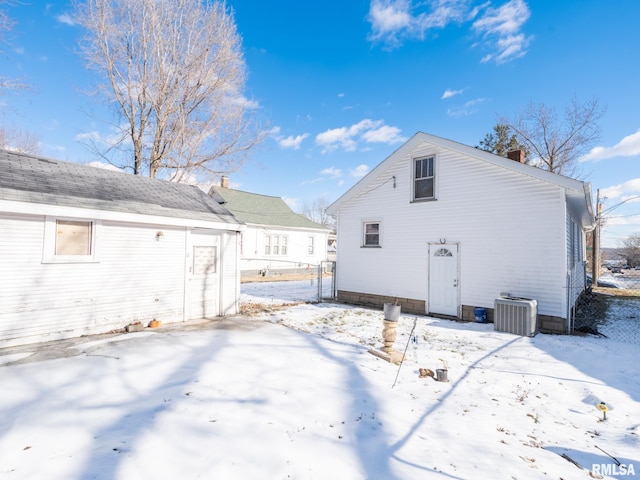 snow covered property with central air condition unit