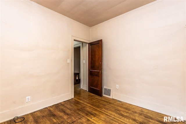 empty room with dark hardwood / wood-style flooring and crown molding