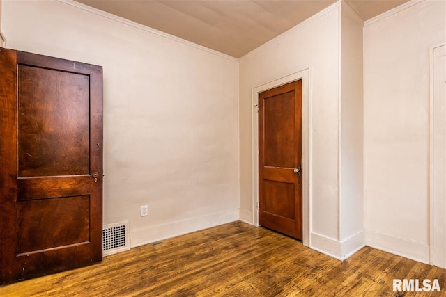 unfurnished room featuring dark wood-type flooring and crown molding