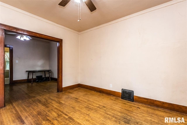 spare room featuring dark wood-type flooring, crown molding, and ceiling fan