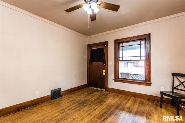 empty room featuring ceiling fan, ornamental molding, and dark hardwood / wood-style flooring