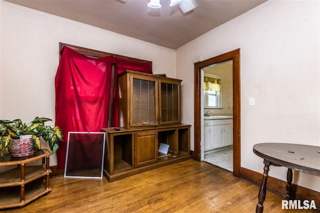 office with hardwood / wood-style flooring, sink, and crown molding