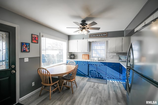 dining room featuring ceiling fan, sink, and light hardwood / wood-style flooring