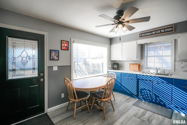 dining area with light wood-type flooring, plenty of natural light, and sink