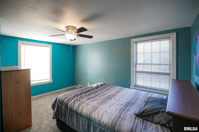 carpeted bedroom featuring ceiling fan and multiple windows