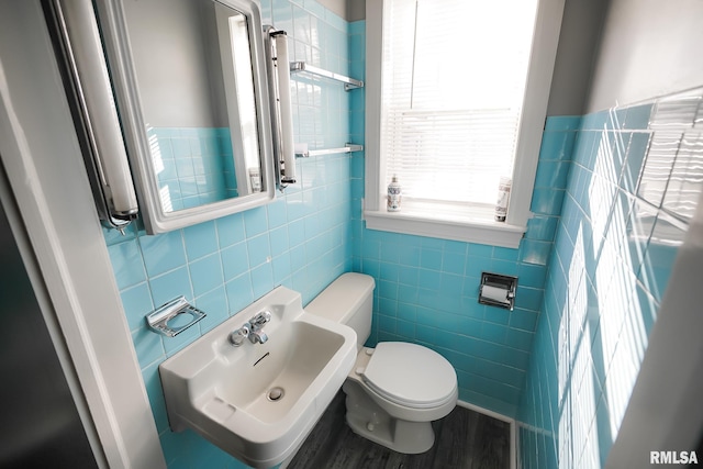 bathroom featuring toilet, tile walls, hardwood / wood-style flooring, and sink