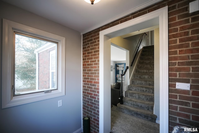 stairs featuring plenty of natural light and brick wall