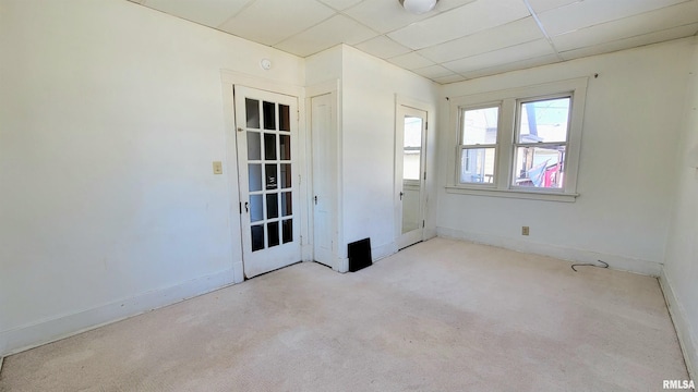 carpeted spare room with a drop ceiling