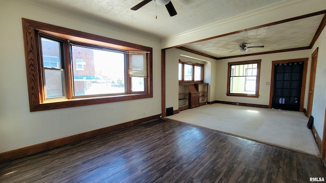 empty room with ceiling fan, a textured ceiling, dark hardwood / wood-style floors, and ornamental molding