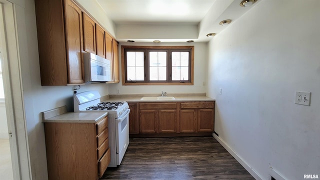 kitchen with dark hardwood / wood-style floors, sink, and white appliances