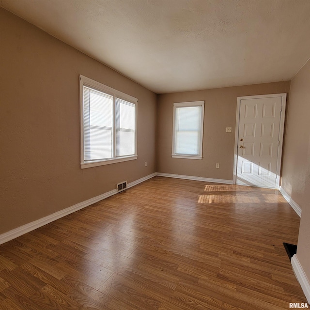 unfurnished room with hardwood / wood-style floors