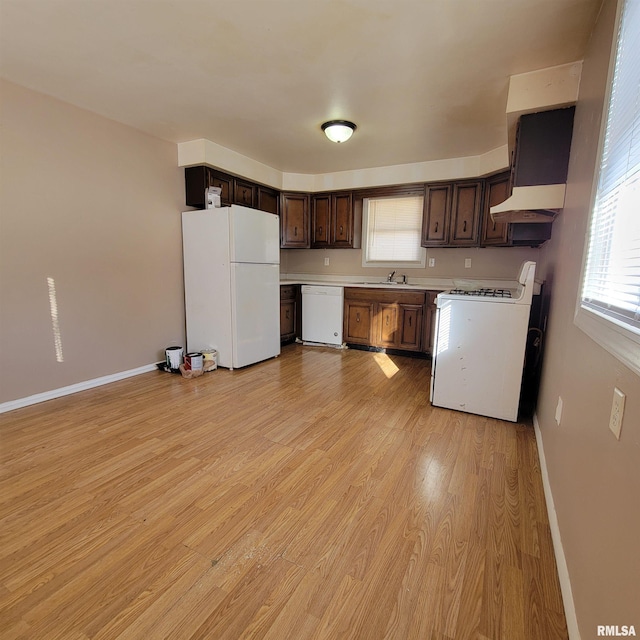 kitchen featuring white appliances, dark brown cabinetry, extractor fan, sink, and light hardwood / wood-style flooring