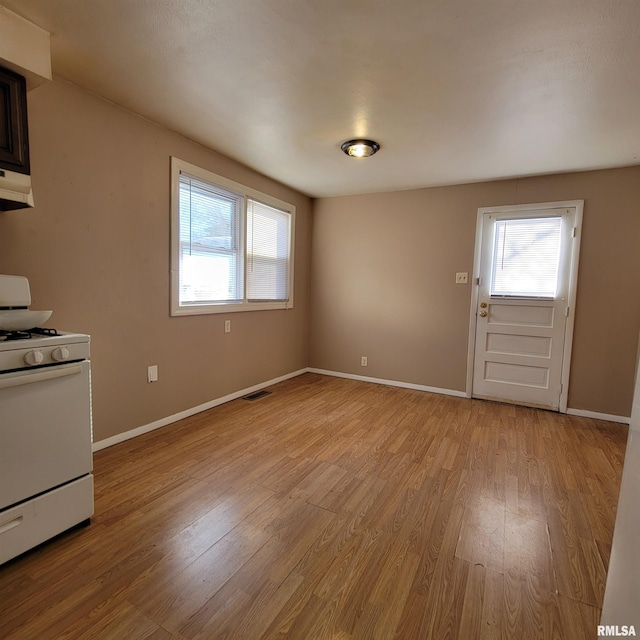 kitchen with white gas range oven and light hardwood / wood-style flooring